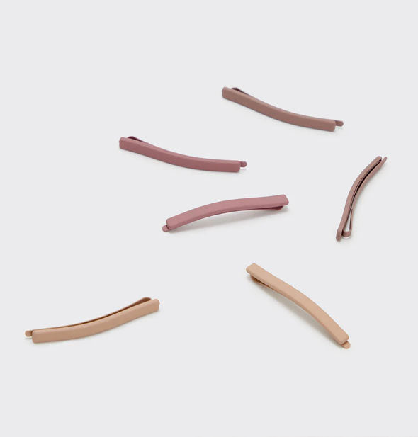 Six bobby pins with matte enamel fronts in warm, earthy neutral shades