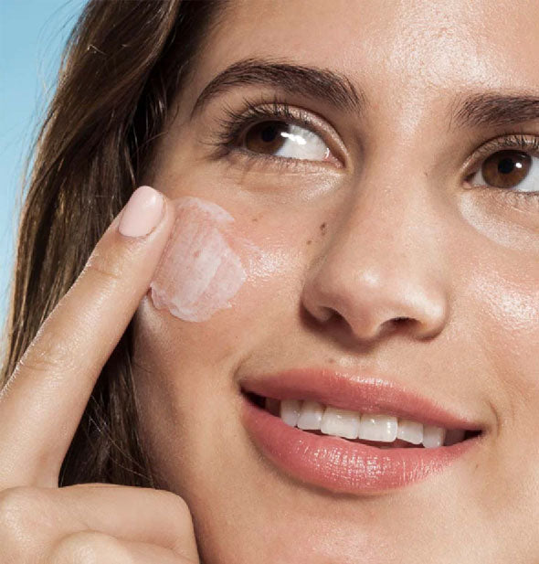 Model applies Elevated Shade sunscreen to cheek