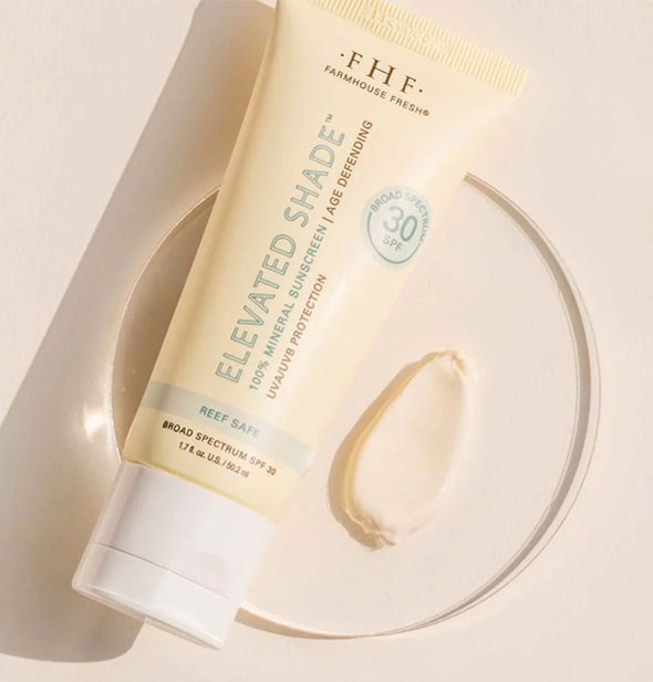 Bottle of FarmHouse Fresh Elevated Shade 100% Mineral Sunscreen with sample application of product on a clear disc