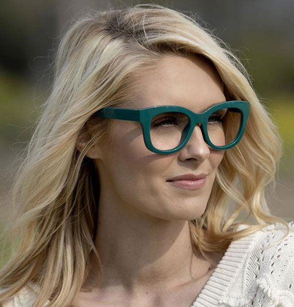 A model wears Peepers Center Stage Readers in Emerald.