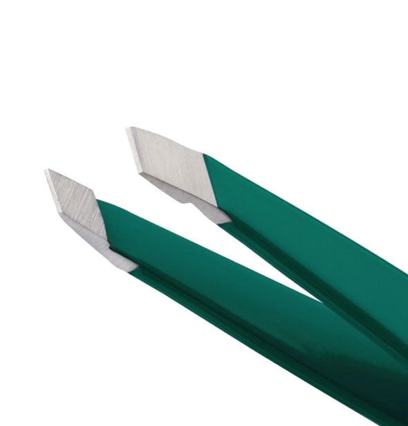 Closeup of angled steel tweezer tips and green tweezer arms