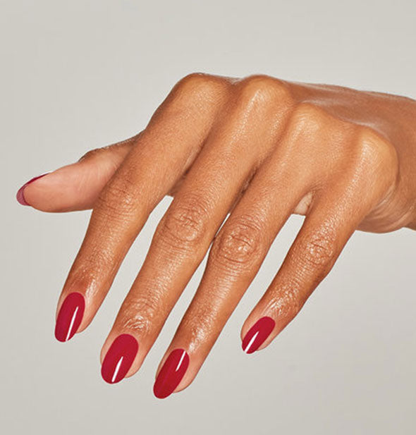 Model's hand wears a classic shade of red nail polish