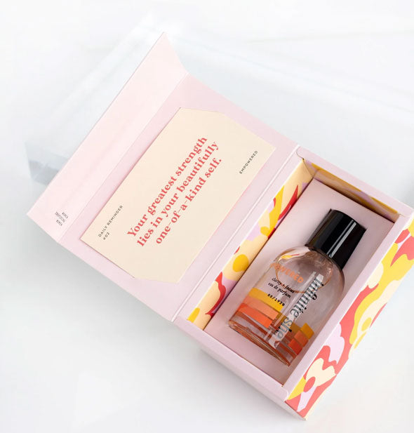 Empowered eau de parfum by Infinite She rests in box packaging which features the quote: "Your greatest strength lies in your beautifully one-of-a-kind self."