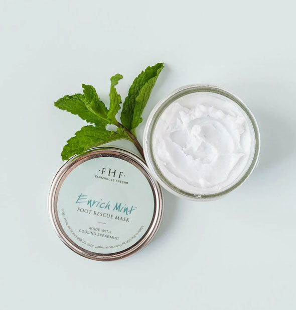 Opened pot of FarmHouse Fresh Enrich Mint Foot Rescue Mask with lid and sprig of spearmint