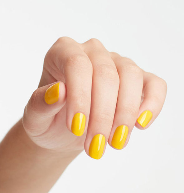 Model's hand wears a shade of bright yellow nail polish
