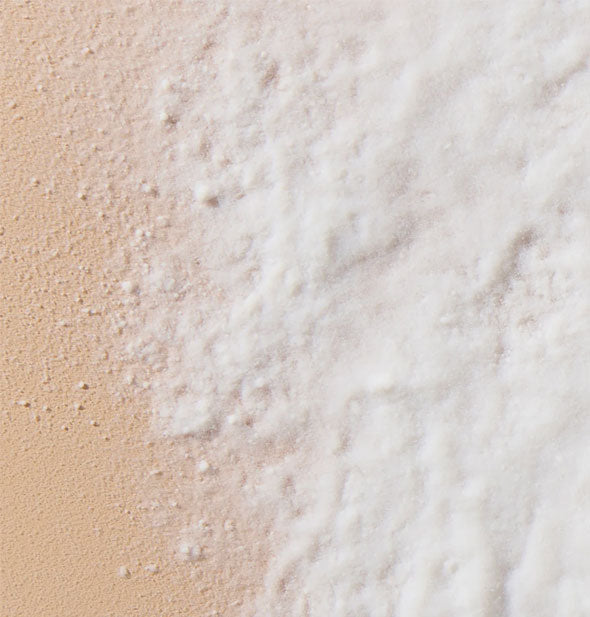 Closeup of a sprinkling of white Unite EXPANDA Dust Volumizing Powder