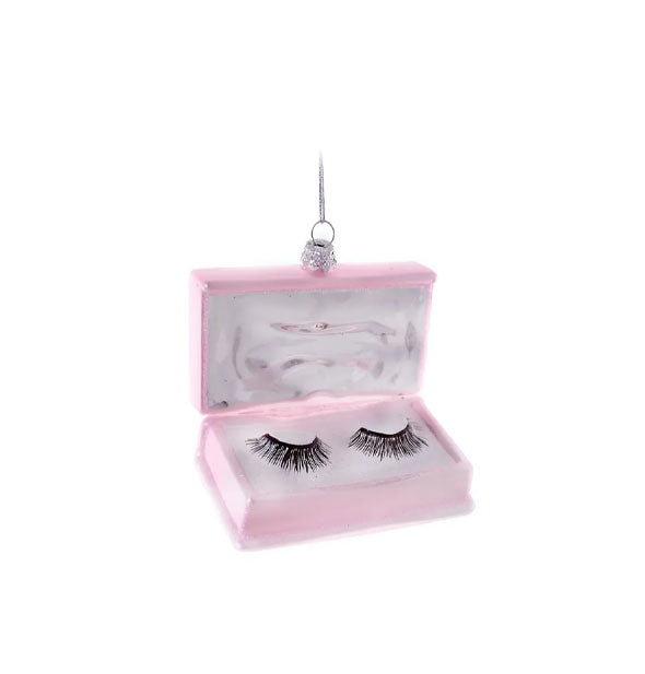 Hanging ornament resembles a pink box containing a pair of false eyelashes