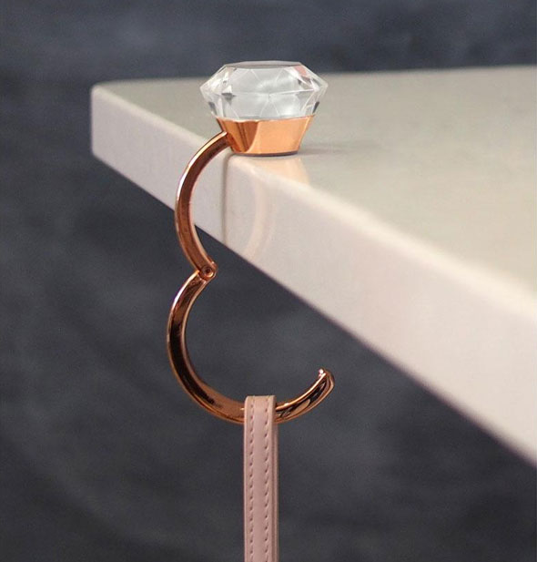 Expanded diamond ring-shaped purse hook shown in use on a tabletop