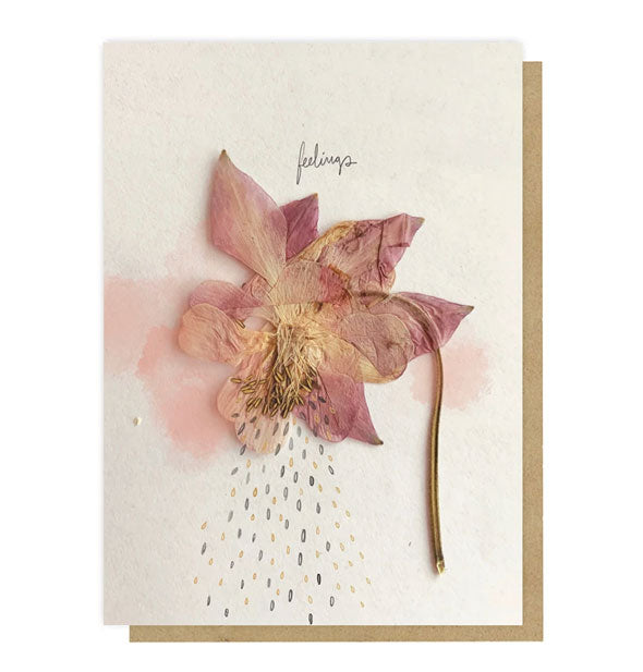 Cream-colored greeting card with kraft envelope behind features a pressed flower design that appears to be weeping tears under the word, "Feelings"
