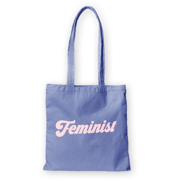 Blue tote bag with long handles says, "Feminist" in pale pink retro-style script lettering
