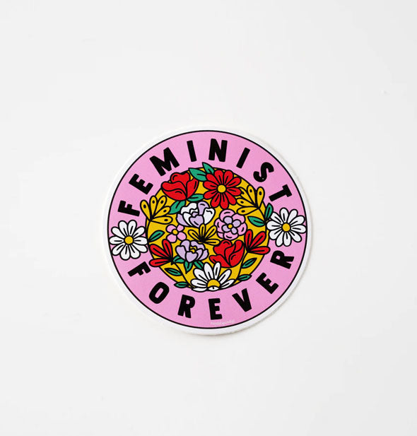 Round pink sticker says, "Feminist forever" in black lettering around a center filled colorful flower illustrations