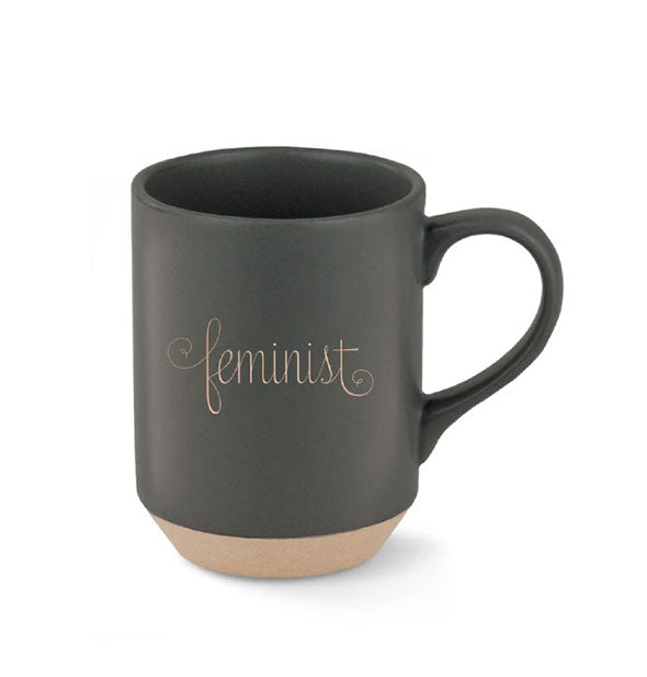 Black mug with tapered matte brown stoneware base says, "Feminist" in decorative gold script