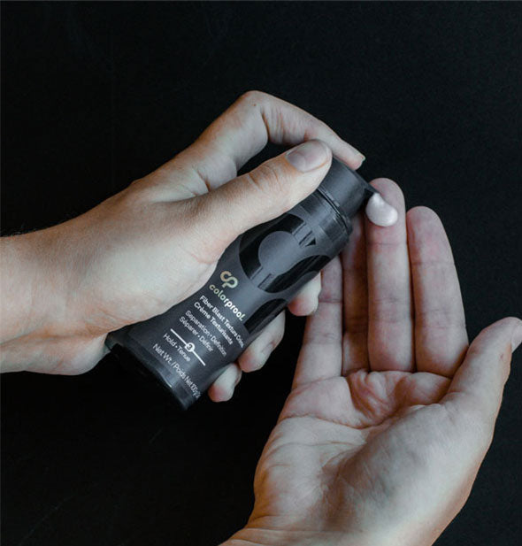 Model's hand dispenses a dollop of ColorProof Fiber Blast Texture Crème onto fingertip