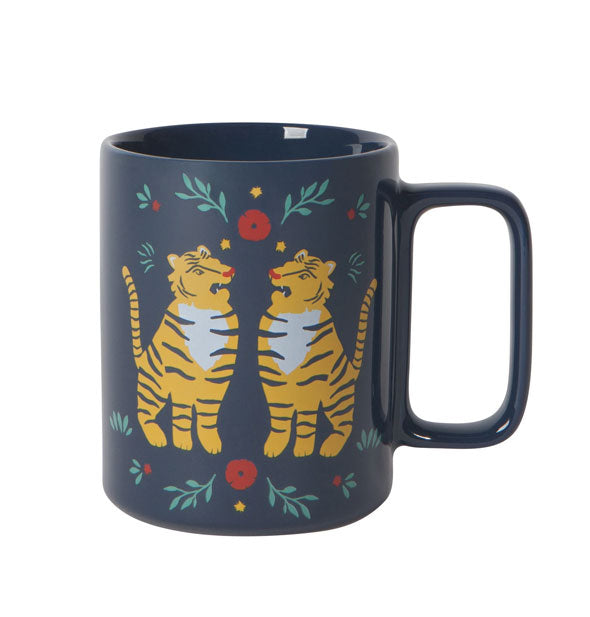 Dark blue coffee mug with rectangular handle and colorful tiger illustrations accented with red and green flowers and leaves