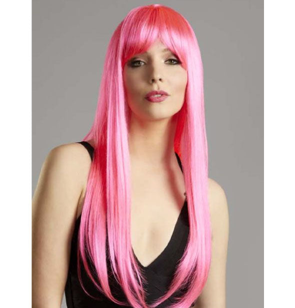 Model wears a long, straight, hot pink wig with bang fringe