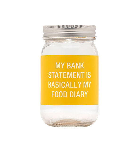 Clear glass jar with metal screw-on cap features a hand-painted yellow color band that says, "My bank statement is basically my food diary" in white lettering