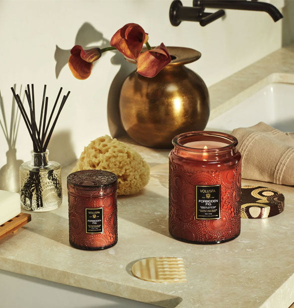 Small and large brown embossed glass candles on bathroom vanity