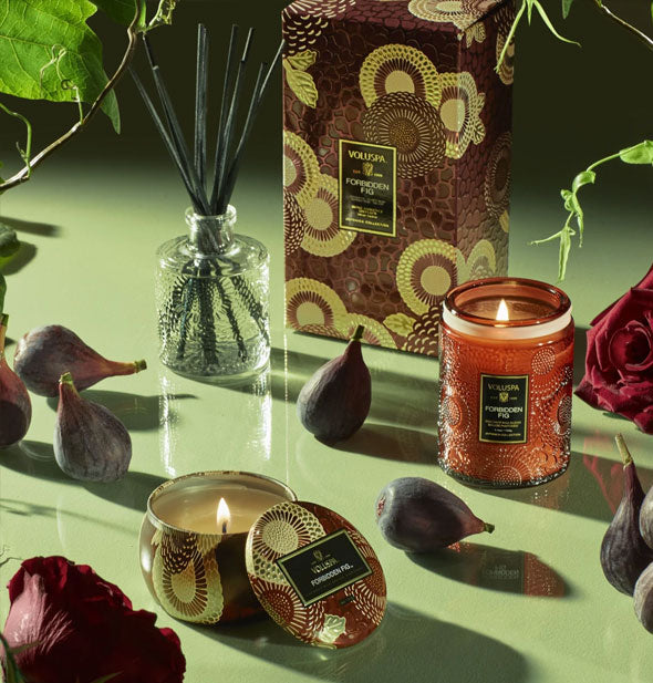 Voluspa candles staged with decorative box, diffuser, figs, and florals