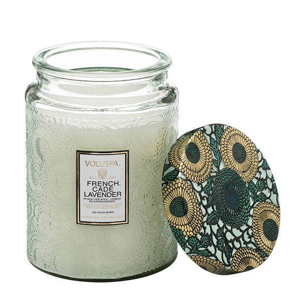 Pale green embossed glass French Cade Lavender Voluspa candle jar with removed metallic green and gold floral lid