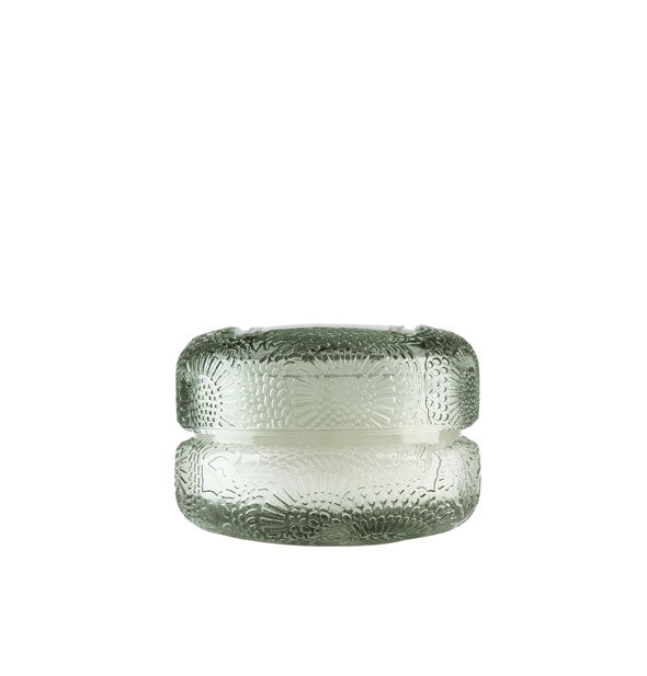 Small green embossed glass candle jar with lid resembles a macaron cookie