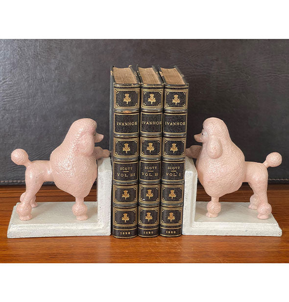 Pink poodle bookends on a shelf hold together three volumes of Ivanhoe