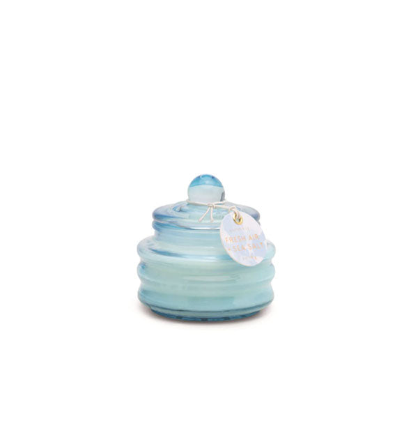 Small blue ribbed glass candle jar with knobbed lid and tag attached
