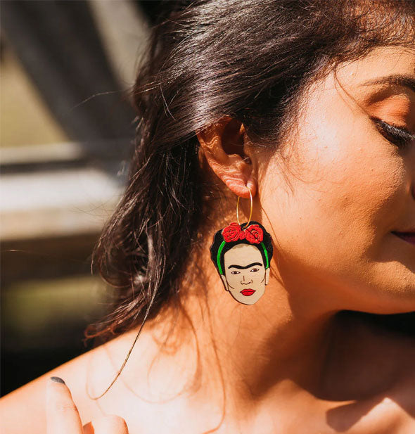 Model wears a colorful Frida Kahlo face earring