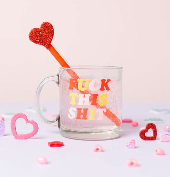 Clear glass Fuck This Shit mug is staged with pink and red glitter hearts