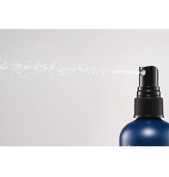 A concentrated mist is dispensed from a bottle of Bumble and bumble Full Potential Booster Spray