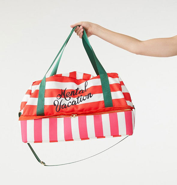 A model's outstretched hand holds the top strap of the Mental Vacation bag