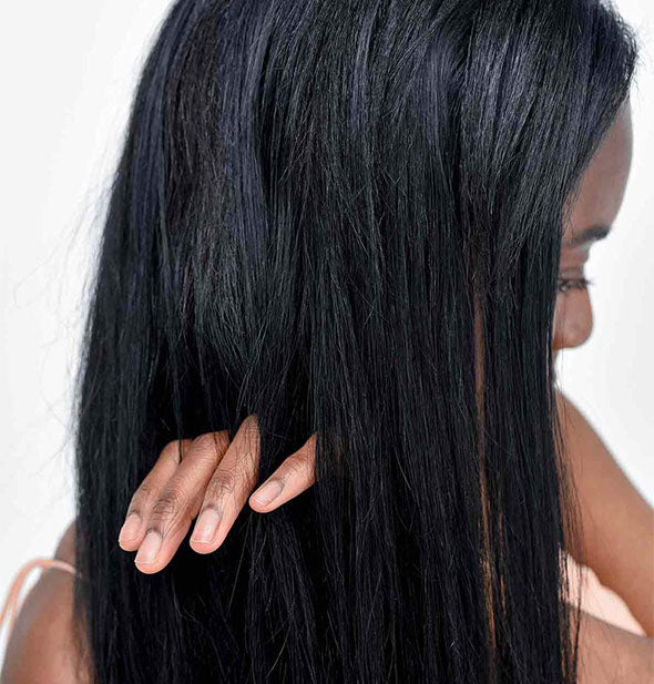 Model runs fingers through hair to demonstrate results of using Verb Ghost Prep