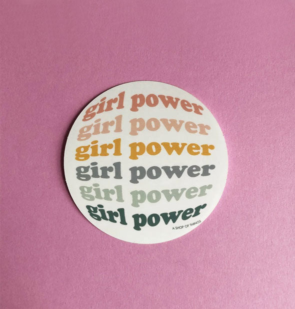 Round white sticker says, "Girl Power" repeated six times in different colors in bulged-out lettering