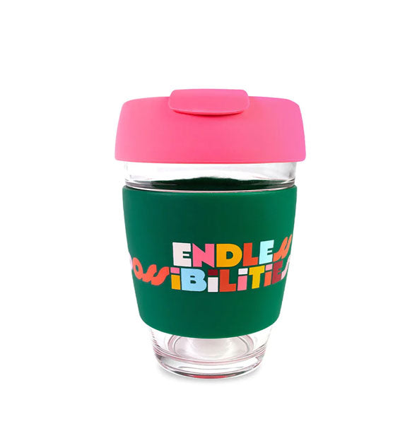Clear glass drink tumbler with pink lid and dark green band that says, "Endless possibilities" in multicolor lettering