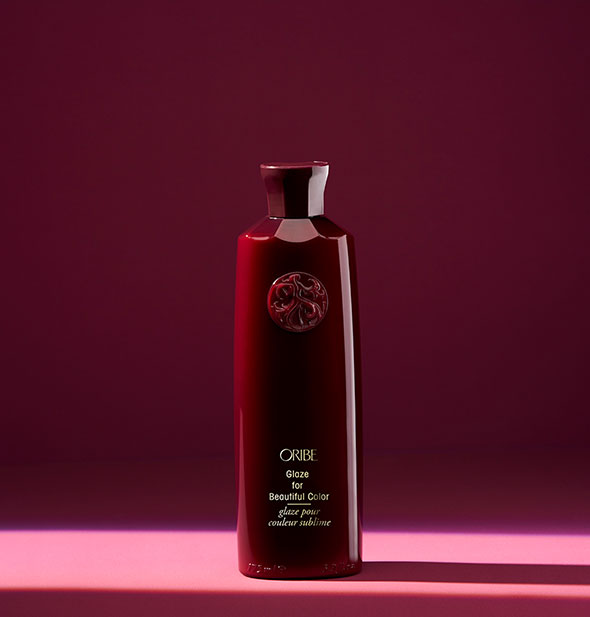 Red bottle of Oribe Glaze for Beautiful Color on red background