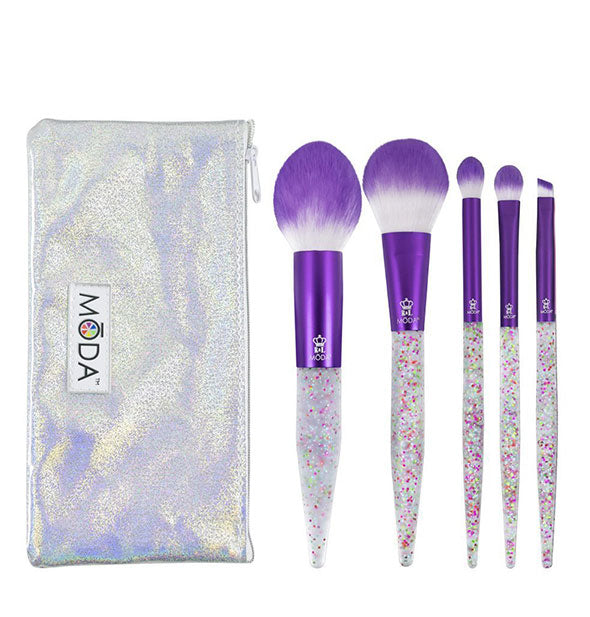 Set of five Moda makeup brushes with purple ferrules, white-to-ombré bristles, and multicolor glitter handles next to an iridescent zippered storage pouch