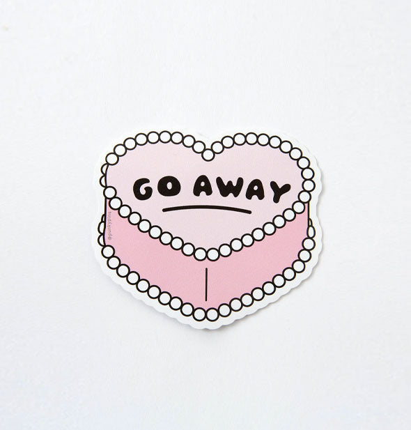 Sticker designed to look like a pink iced heart-shaped cake says, "Go away" in black lettering