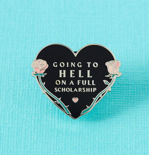 Going to Hell on a Full Scholarship black enamel pin on textured teal background