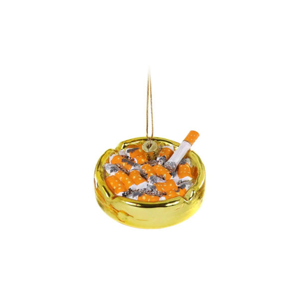 Round ornament painted to resemble a gold ashtray filled with cigarette butts