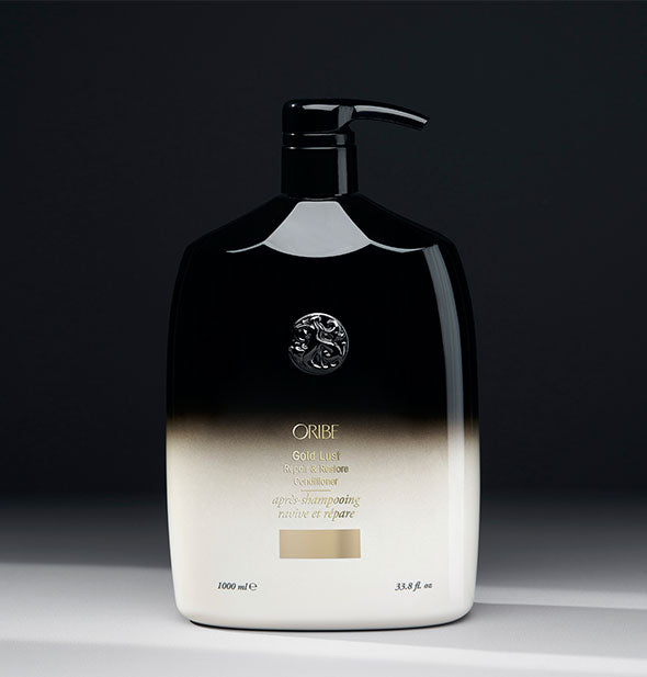 33.8 ounce black-to-white bottle of Oribe Gold Lust Repair & Restore Conditioner on gray background