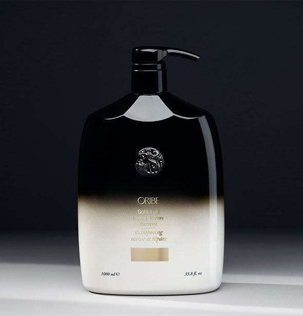 33.8 ounce black-to-white bottle of Oribe Gold Lust Repair & Restore Shampoo on gray background