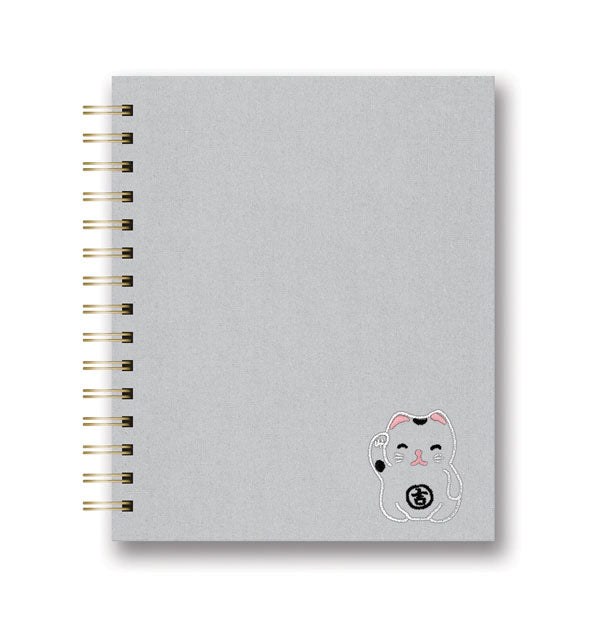 Gray notebook with twin-ring spiral binding features embroidered lucky cat illustration in bottom right corner