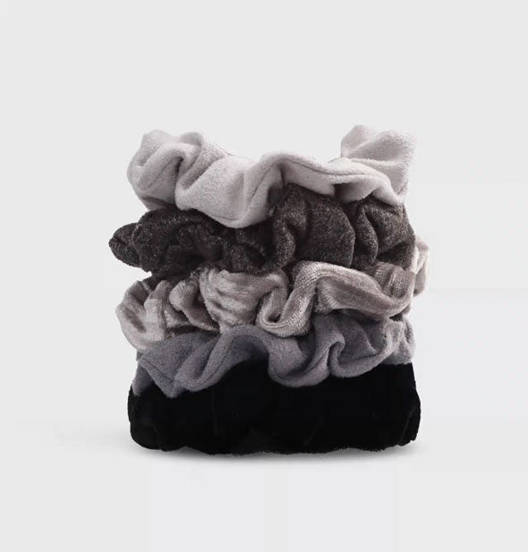 Stack of five hair scrunchies with gray toned velvet fabrics