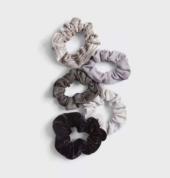 Five hair scrunchies with gray toned velvet fabrics