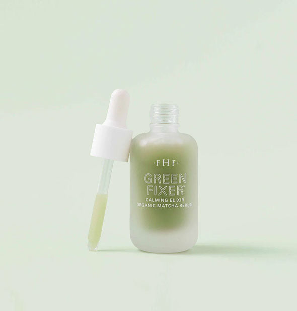 Bottle of FHF Green Fixer Calming Elixir Organic Matcha Serum with dropper applicator removed and leaned alongside