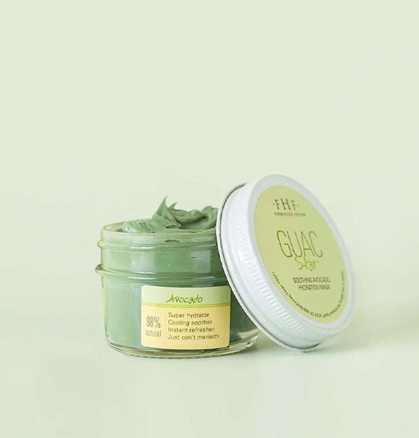Pot of green Guac Star Avocado face mask by FarmHouse Fresh with lid removed and propped up alongside