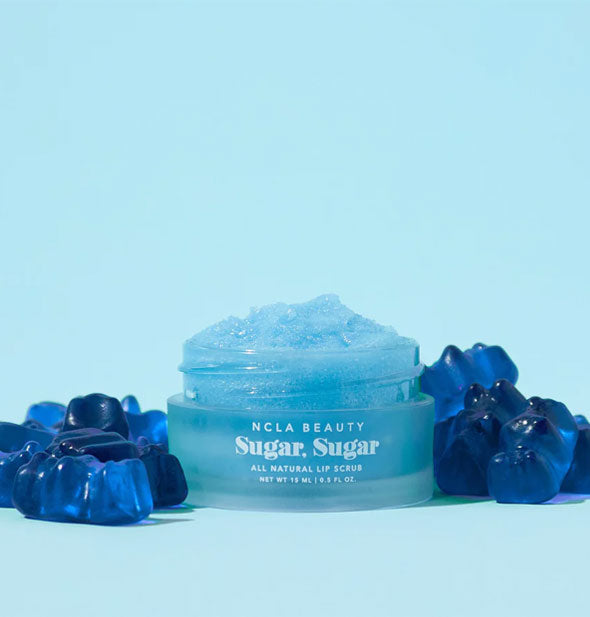 Pot of blue NCLA Beauty Sugar, Sugar All Natural Lip Scrub is flanked by bkue gummy bears