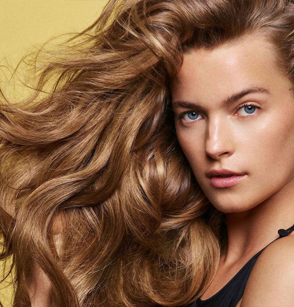 Model with very healthy-looking hair demonstrates the results of using Oribe's Hair Alchemy products