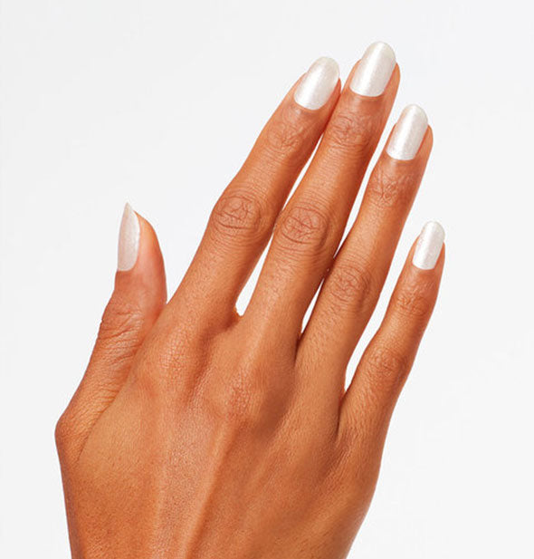 Model's hand wears silver-white nail polish with a pearlescent finish