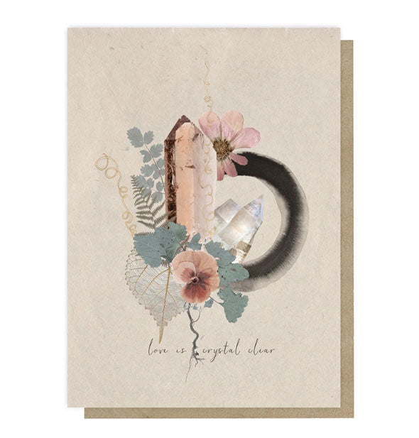 Tan-colored card with kraft envelope behind features a design of crystal quartz illustrations, watercolor brushstroke, and pressed flowers and leaves