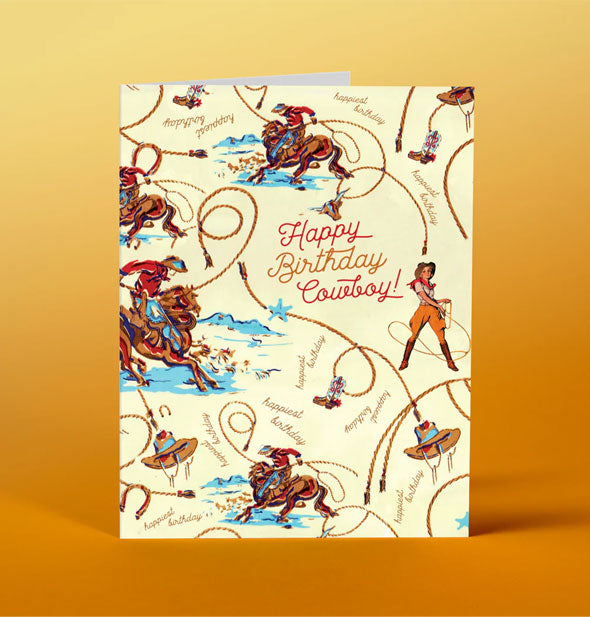 Greeting card with all-over cowboy and cowgirl illustrations accented by ropes and other Western elements says, "Happy Birthday Cowboy!"